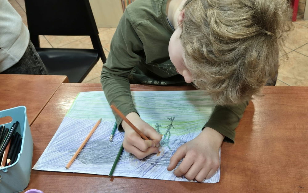 chłopiec rysuje ilustrację do teatrzyku kamishibai