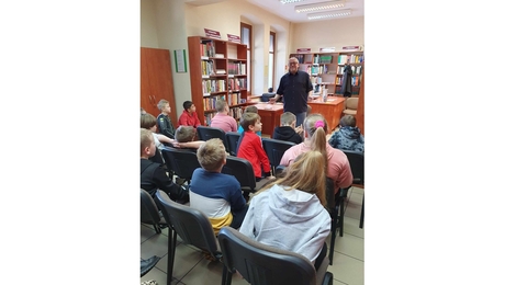 Marcin pałasz z uczniami w bibliotece w Łozinie
