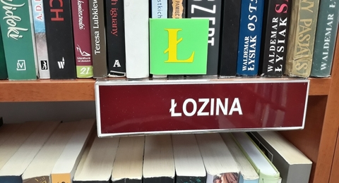 tabliczka łozina na półce z książkami