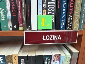 tabliczka łozina na półce z książkami