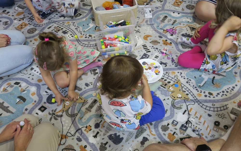 dzieci na dywanie podczas zajęć klubu małego czytelnika