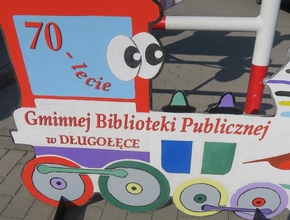 Makieta pociągu z napisem siedemdziesięciolecie Gminnej Biblioteki Publicznej w Długołęce