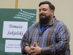 Tomasz Sekielski na spotkaniu autorskim zorganizowanym przez bibliotekę w Długołęce, miejsce spotkania Urząd Gminy